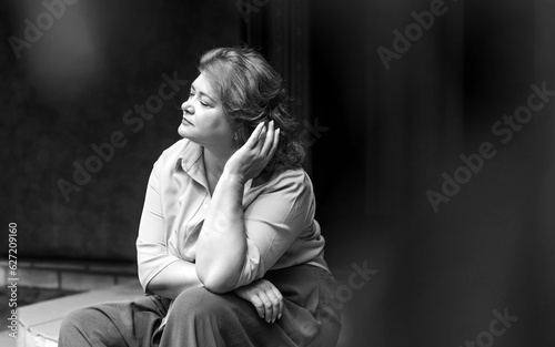 Sad plump middle aged woman thinking about something, crisis of middle age and problems among overweight people