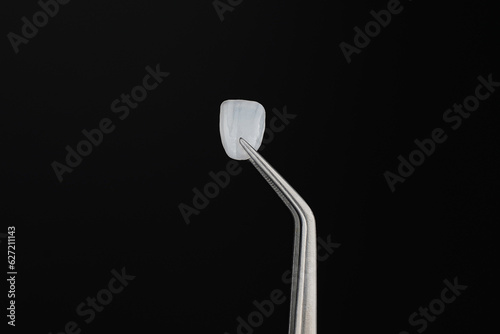 фотографія ceramic Veneer Dental Smile design White teeth Close-up super thin porcelain laminated veneer measurement with a vernier caliper to show the thickness or smile makeover treatment
