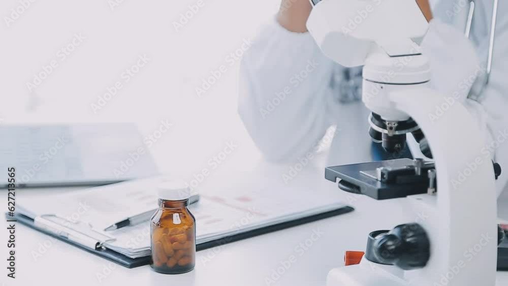 biochemical research scientist team working with microscope for coronavirus vaccine development in pharmaceutical research labolatory, selective focus biochemical research scientist team working with microscope for coronavirus vaccine development in pharmaceutical research labolatory, selective focus