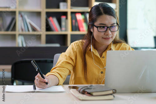 Digital Learning: Woman Wearing Headphones Engaged in Online Education