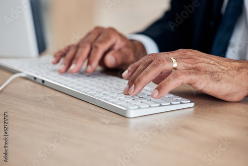 Hands, keyboard and a business man typing while working on a computer in his office for management. Email, desk and administration with a male employee at work to draft a proposal or feedback report