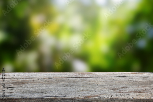 Vintage wooden tabletop on green bokeh nature background, for product display