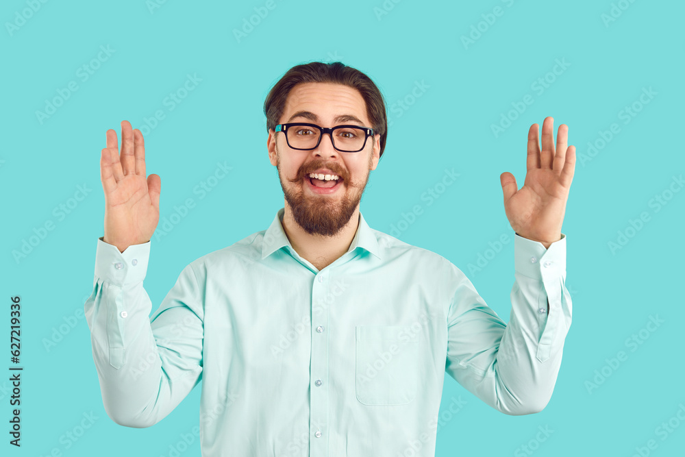 Happy joyful young man in shirt and glasses holding hands apart to show how huge something is. Funny cheerful excited nerd student on blue background telling and boasting about object of very big size Happy joyful young man in shirt and glasses holding hands apart to show how huge something is. Funny cheerful excited nerd student on blue background telling and boasting about object of very big size