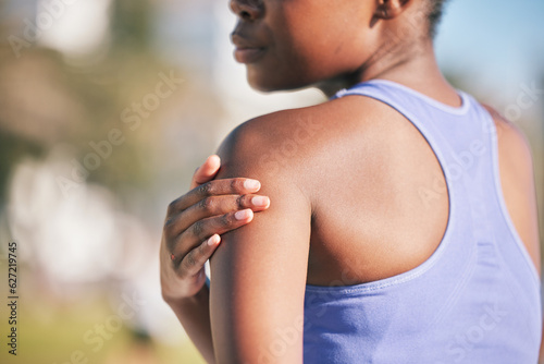Arm  pain and woman with injury in outdoor for training accident from sport with exercise or body. Runner  shoulder and muscle strain with female athlete after workout at park for cardio or wellness.