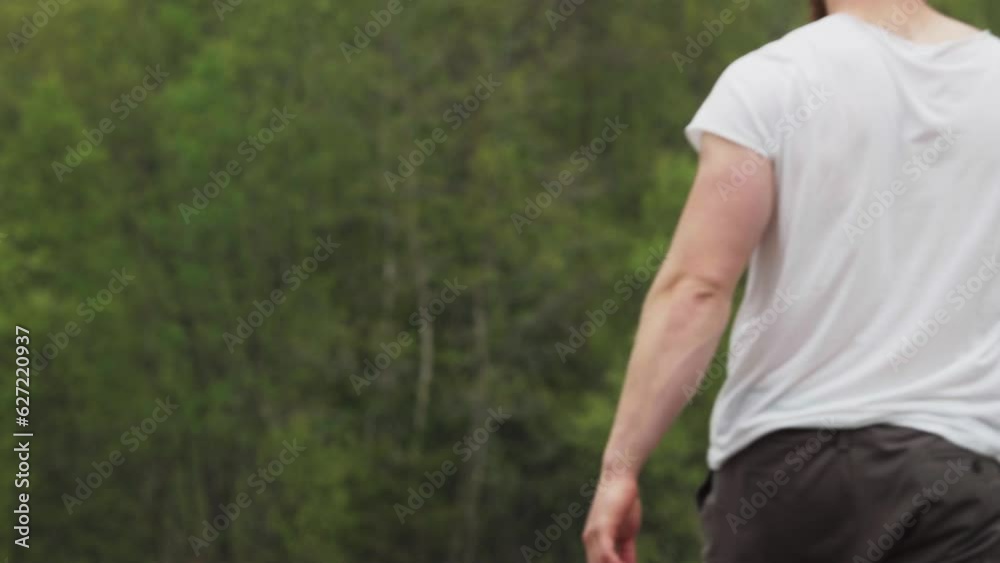 Defocus Nature With A Man Showing Muscles Is Holding An Axe. Medium Shot Defocus Nature With A Man Showing Muscles Is Holding An Axe. Medium Shot