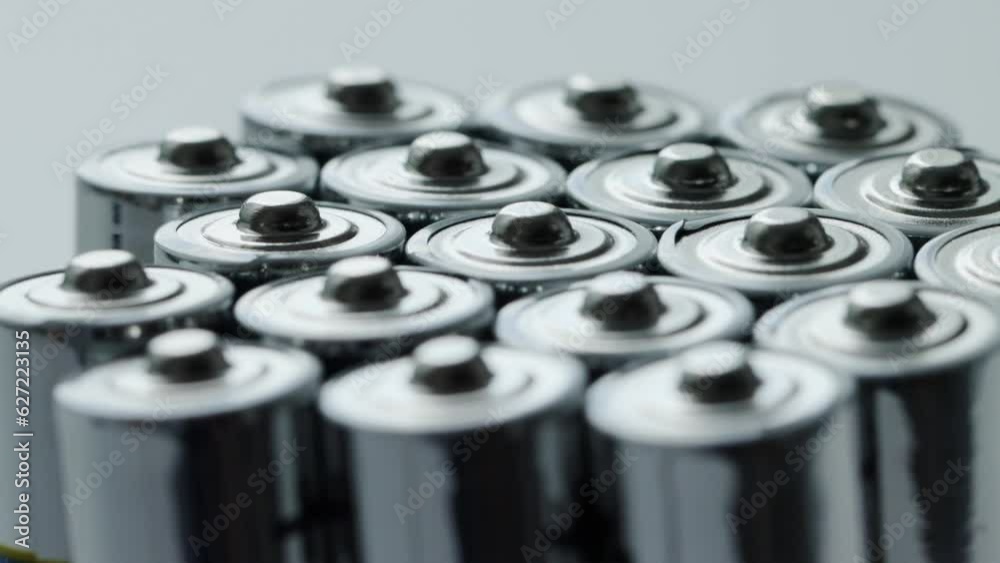 A lot of alkaline charged batteries with different polarity and power. Battery recycling, plus and minus, background. Rotation around its own axis. Macro A lot of alkaline charged batteries with different polarity and power. Battery recycling, plus and minus, background. Rotation around its own axis. Macro