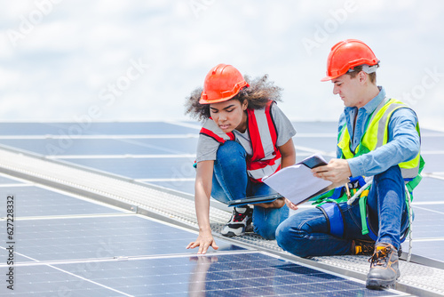 Engineer technician team using laptop checking and operating system on rooftop of plant farm, Renewable energy source for electricity and power, Solar cell panel maintenance service concept