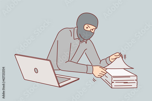 Man gangster steals documents from office building, wearing mask to hide face and remain anonymous