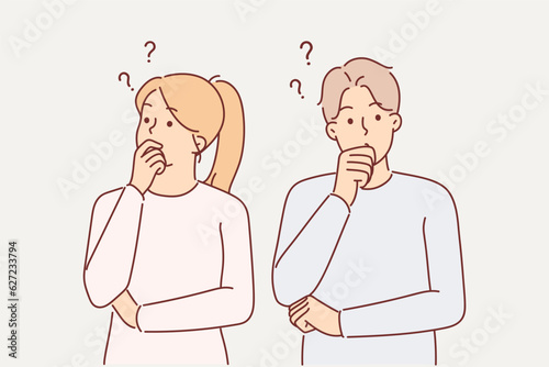 Thoughtful couple touches their chins in embarrassment when pondering important question