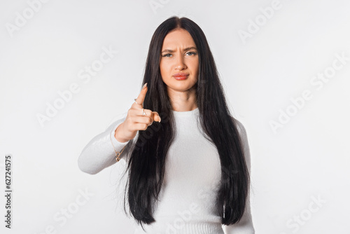 Angry young woman arguing shake index finger, punishing mischief, standing against white studio background. Girl looking displeased asking for obedience and demanding respect