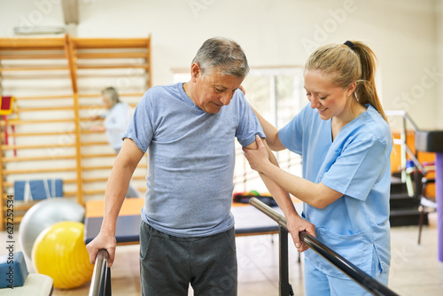 Physiotherapist assisting elderly man in movement therapy