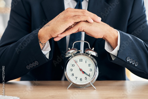 Clock, business man and time management in office for deadline, punctual and busy schedule. Hands of professional person or broker working at desk with alarm, reminder and timer for goals and agenda photo