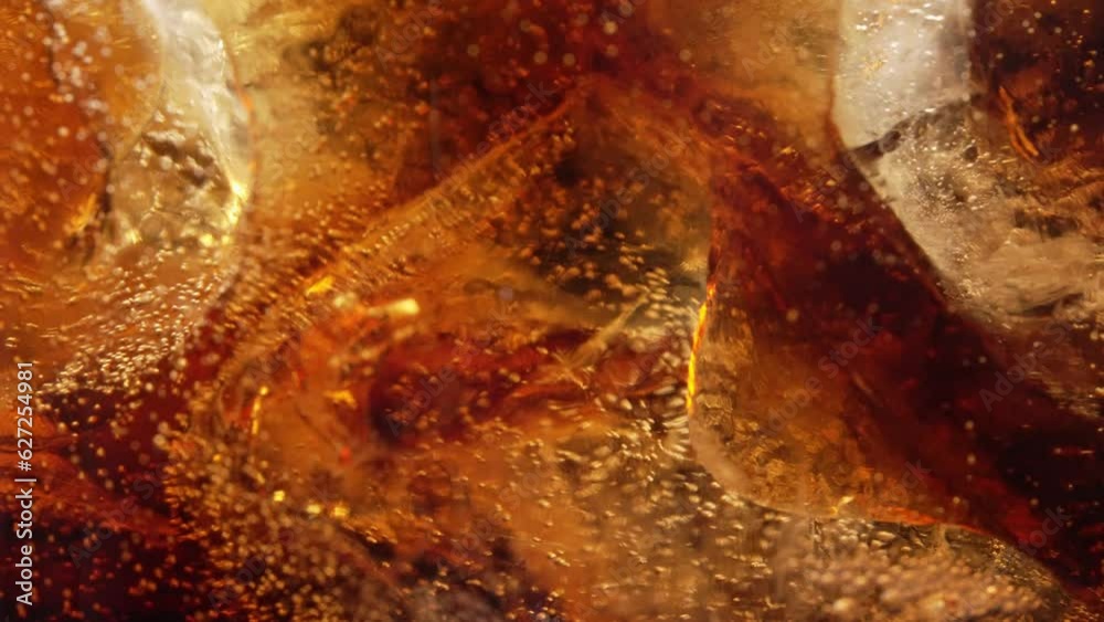 Bubbles and Ice Cubes in a Glass of Cola or Lemonade