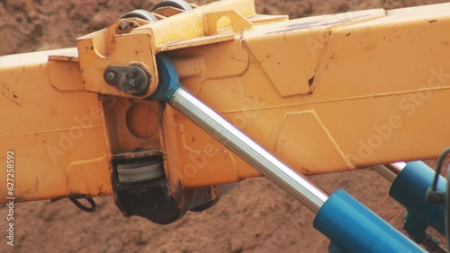 The work of hydraulic cylinders in the retractable boom of the excavator, close-up. Industry