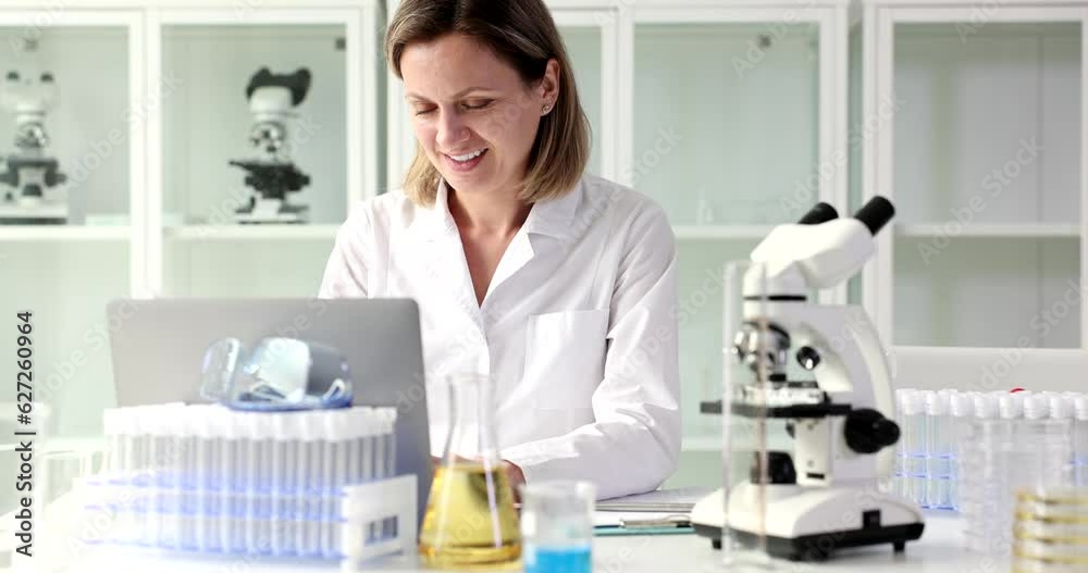 Scientist typing in laboratory on a laptop for online research or healthcare. Happy doctor or medical worker with PC for testing Scientist typing in laboratory on a laptop for online research or healthcare. Happy doctor or medical worker with PC for testing