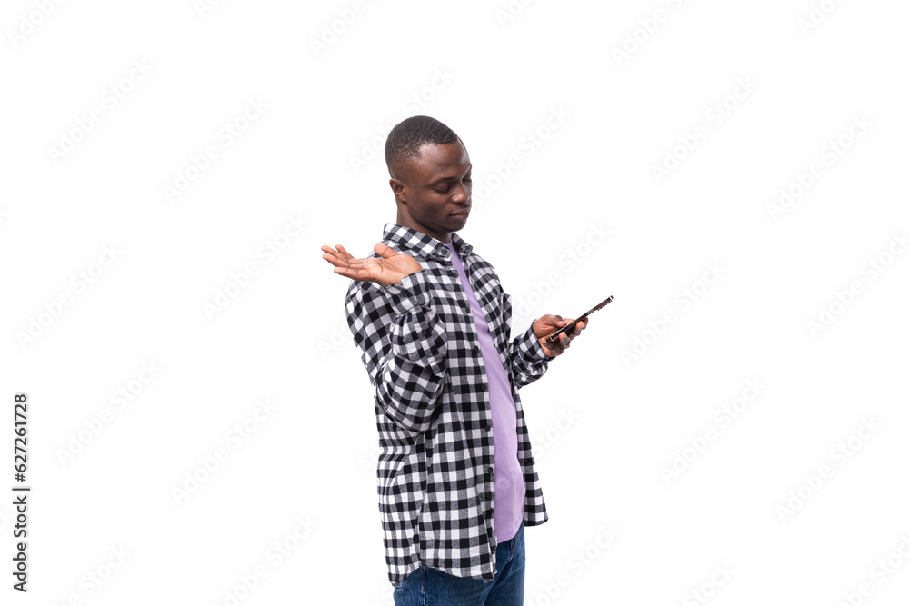 handsome young african man with short haircut in plaid shirt chatting on social network in smartphone handsome young african man with short haircut in plaid shirt chatting on social network in smartphone
