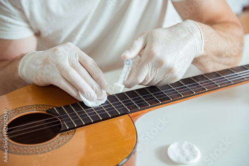 Obraz na plátně Cleaning and maintenance of a guitar