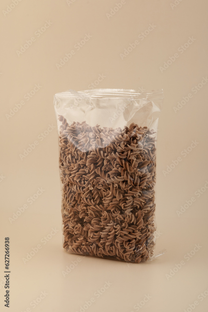 Pasta di Lino. Flaxseed gluten free pasta in transparent bag on beige