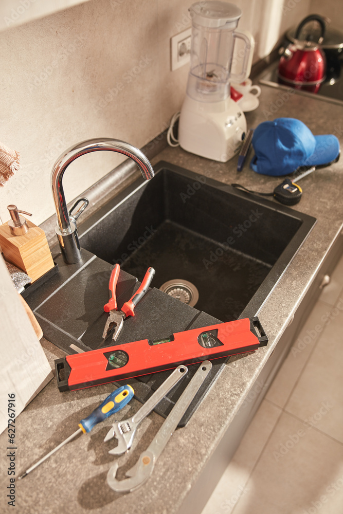 Plumber tools for fixing and repairing water tap on the kitchen sink. Plumber tools for fixing and repairing water tap on the kitchen sink.