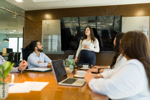 Pregnant businesswoman giving a presentation to colleagues in boardroom