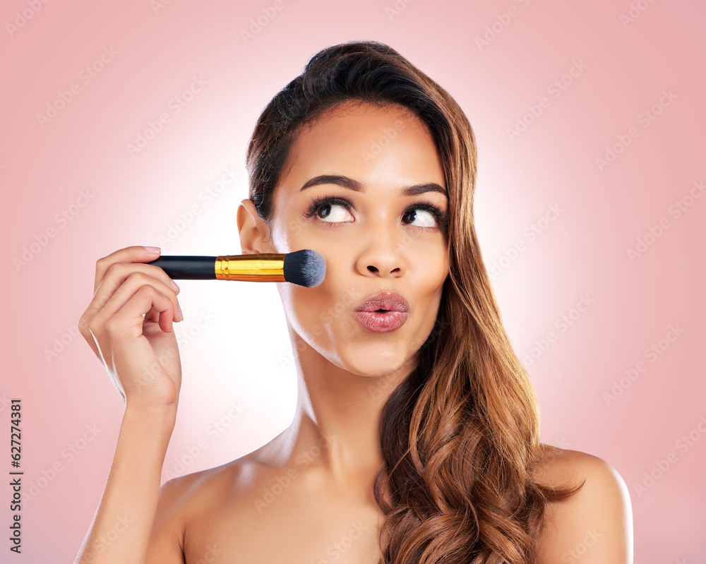 Fototapeta premium Beauty, makeup and face of woman with brush on pink background for salon, wellness and luxury. Cosmetology, aesthetic and female person with tools for foundation, cosmetics and glamour in studio
