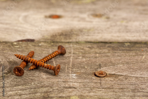 Old weathered pine wood decking planks with rusty screws