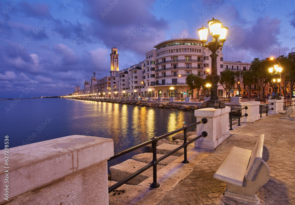 Empty benches and lamp posts at seafront and promenade in Bari, Italy. Romantic, calm, relaxing evening in city.