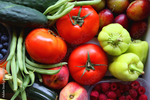 Wooden crate full of healthy colorful seasonal fruit and vegetable. Top view.