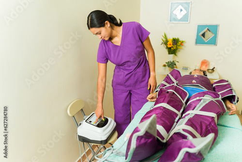 Tableau sur toile Therapist using the pressotherapy machine at the spa