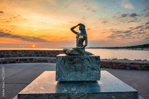 Mermaid statue by the Baltic Seain Ustka at sunrise. Poland photo