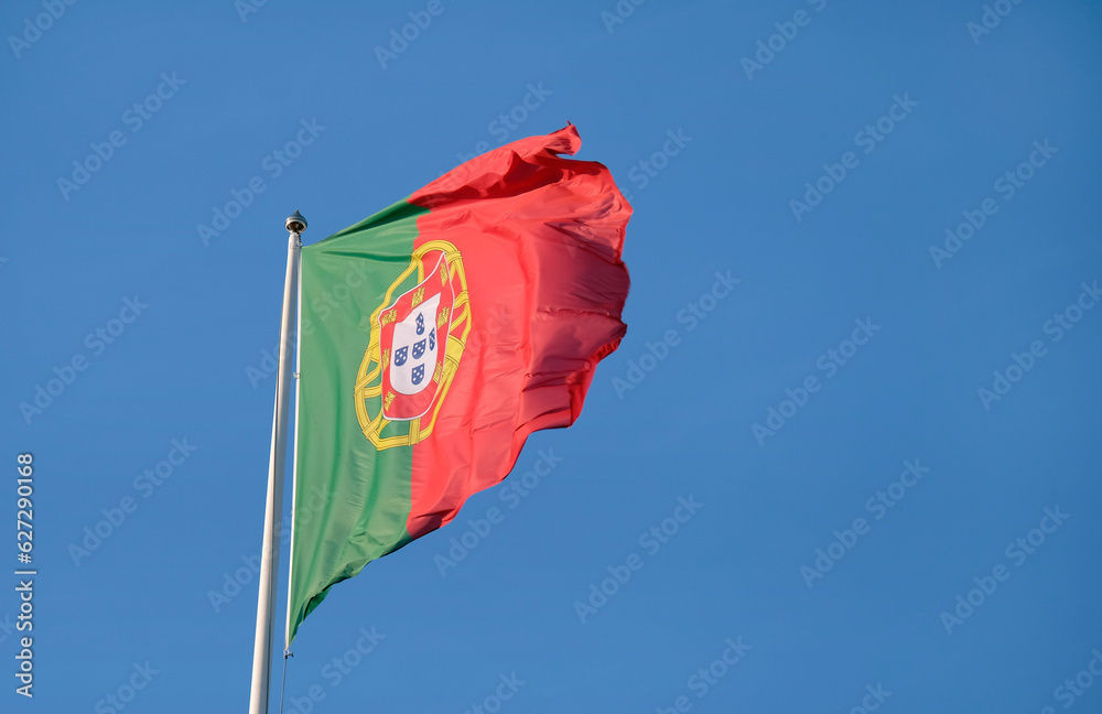 Portuguese flag waving in the wind against a clear sky