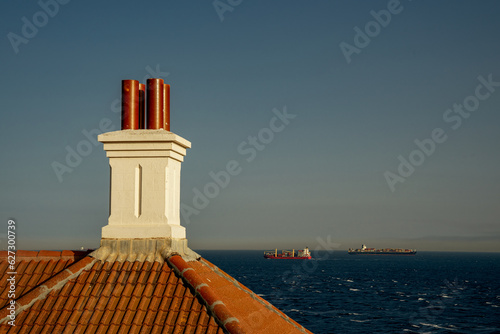 Obraz na płótnie Latarnia morska Europa Point. Komin budynku latarni w tle kontenerowiec morski. w salonie