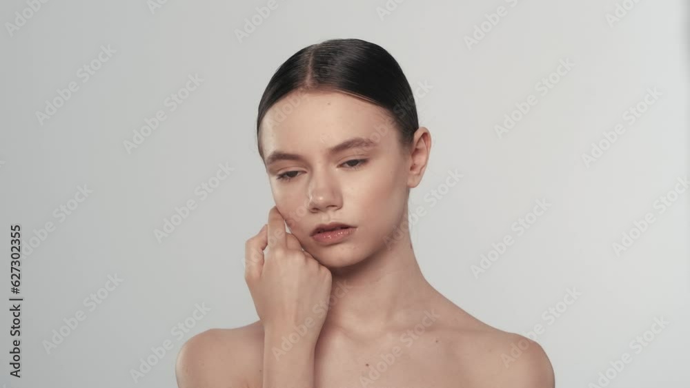 Brunette young woman model touching her perfect skin and looking at the camera Brunette young woman model touching her perfect skin and looking at the camera