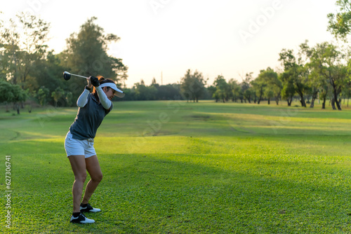 Wallpaper Mural Golfer women sport course golf ball fairway. People lifestyle woman playing game golf swing tee of on the green grass sunset background. Asian female player game shot in summer. copy space for text Torontodigital.ca