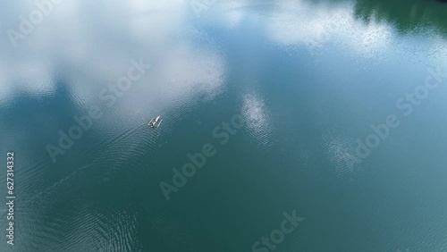 A small ship sails on crystal blue water. Aerial view Lake Danao Philippines  photo