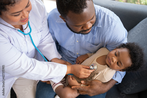 Pediatrics doctor with stethoscope for lungs or chest checkup for examining cute little girl in medical healthcare hospital or clinic. Doctor check Heart And Lungs for Smiling African American Baby.