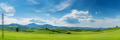 Panoramic natural landscape with a green grass field, blue sky with clouds, and mountains in the background. Panorama summer spring meadow. Generative AI.