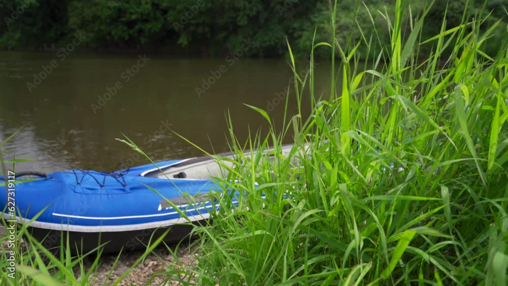 A man loading a kayak on a river with a large backpack A man loading a kayak on a river with a large backpack