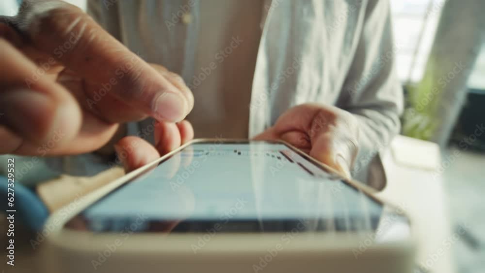 Close-up shot of unrecognizable African American man holding smartphone in hands, reading article on internet. Male hands increasing text. Businessman in casual outfit browsing on device on blurred Close-up shot of unrecognizable African American man holding smartphone in hands, reading article on internet. Male hands increasing text. Businessman in casual outfit browsing on device on blurred