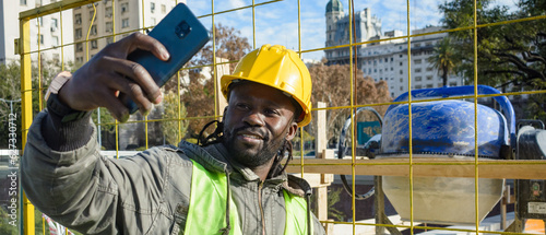 banner of african man construction worker taking a selfie with the machines in the background