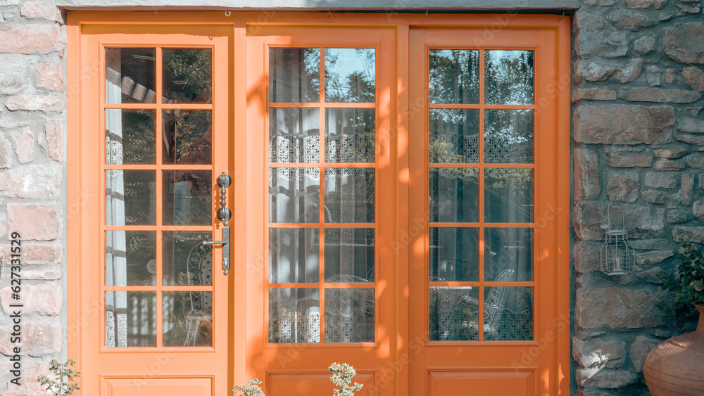 orange painted entrance door to the stone house in Gokceada Imbros island. 