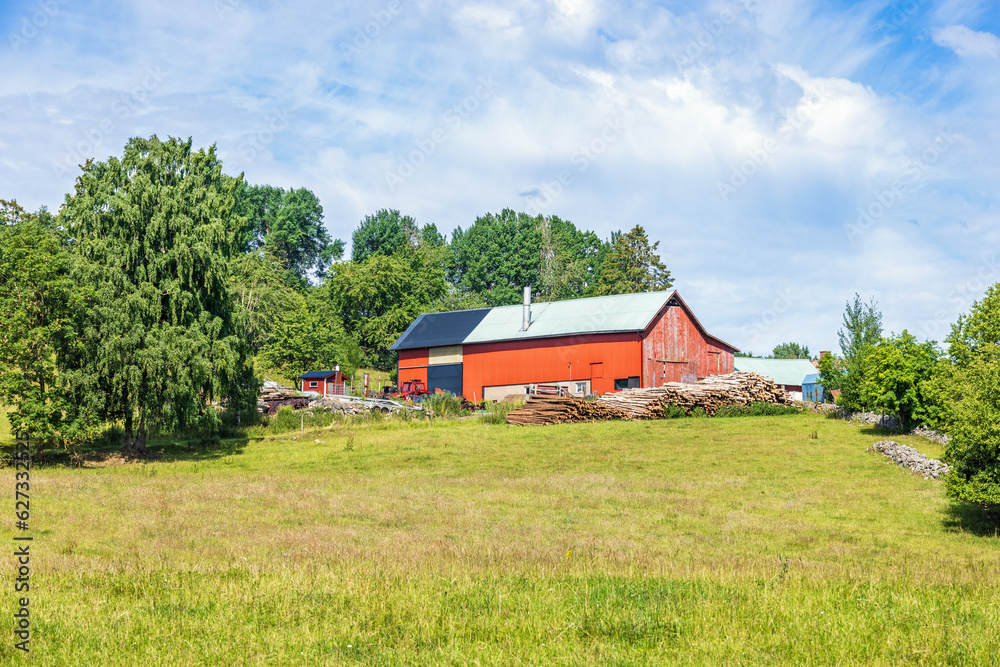 Red barn with a wood pile in the countryside Red barn with a wood pile in the countryside