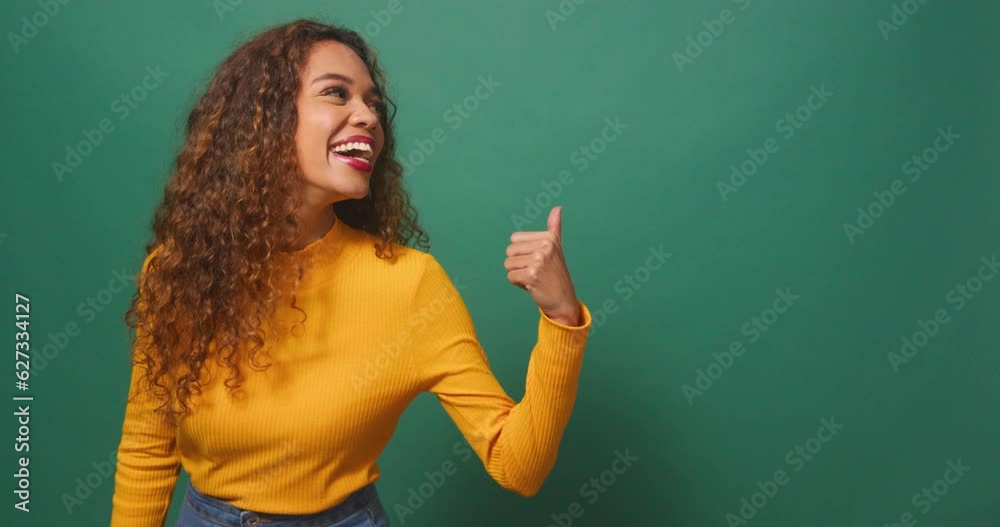 Beautiful young woman points to copy space right, excited, sale, green studio Beautiful young woman points to copy space right, excited, sale, green studio