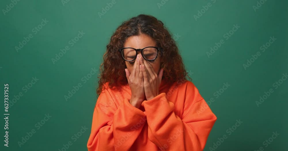 Young biracial woman yawns and covers mouth, green background studio video Young biracial woman yawns and covers mouth, green background studio video