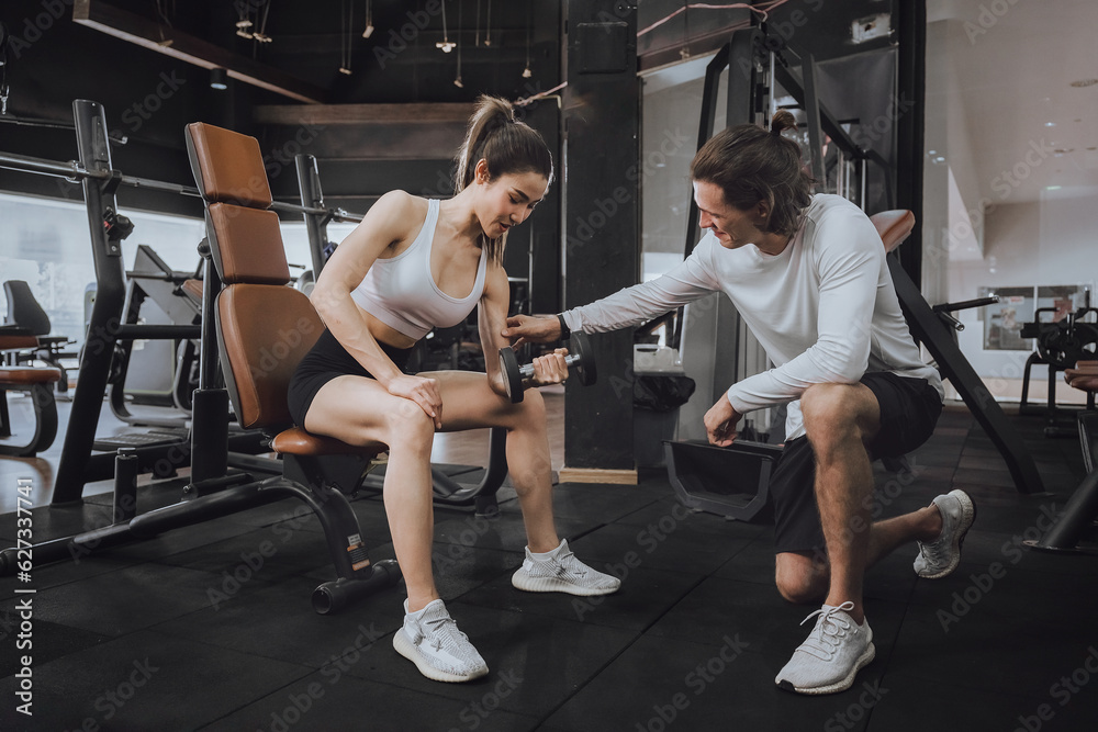 Obraz premium Workout, Fitness workout in gym with trainer assisted in training, Fitness concept, Fit asian woman, Young white man and asian girl exercising in the gym.