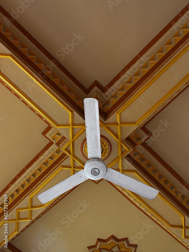 White ceiling fan on brown ceiling.