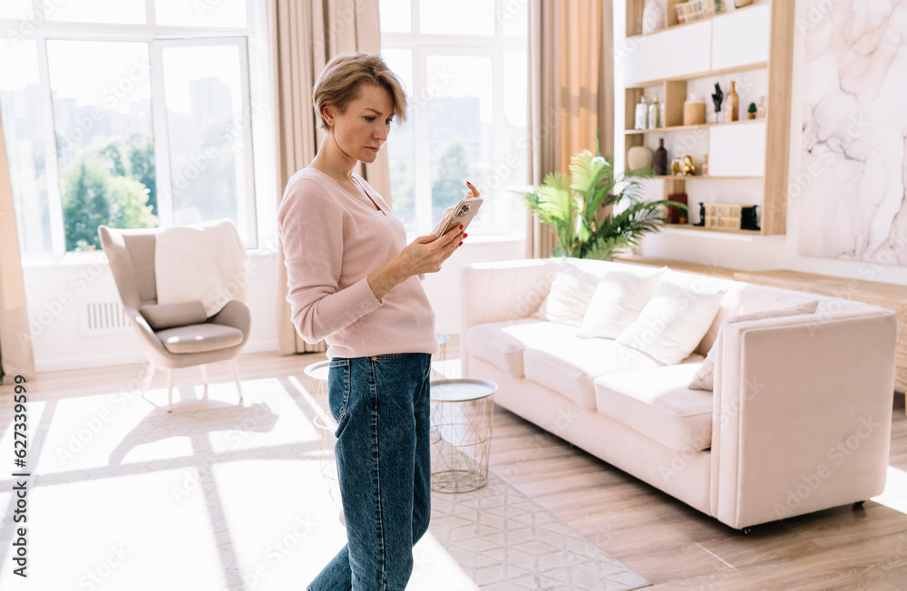 Serious woman looking at smartphone screen at home Serious woman looking at smartphone screen at home