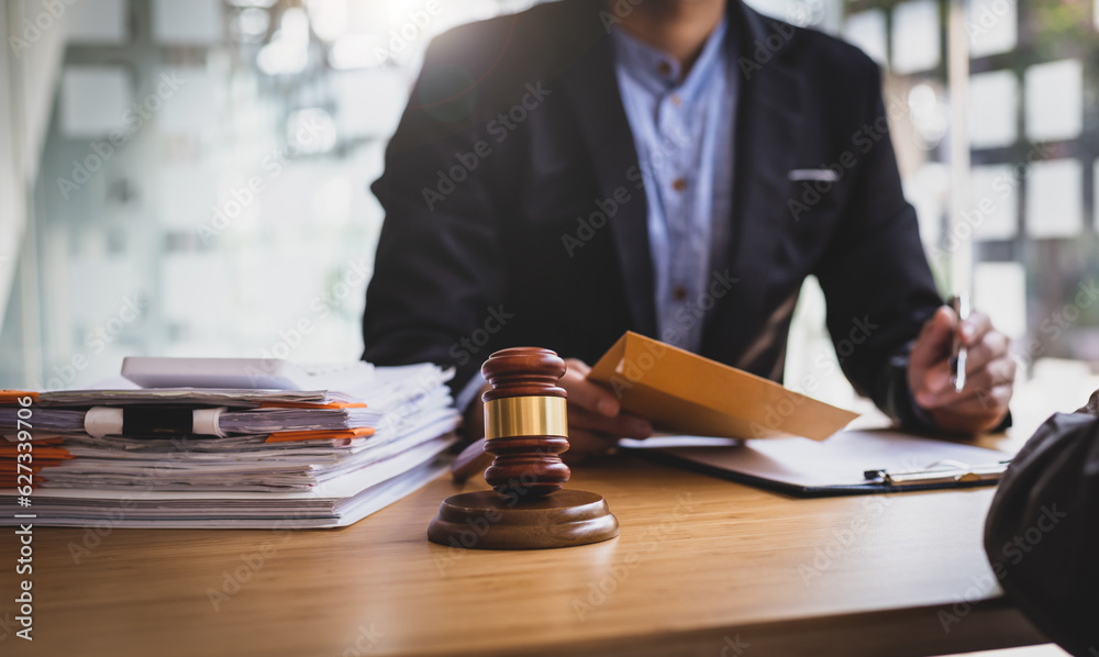 Businessman and lawyer discuss the contract document. Treaty of the law. Sign a contract business. Consultation of Businessman and lawyer or judge counselor, Law and Legal services concept. Businessman and lawyer discuss the contract document. Treaty of the law. Sign a contract business. Consultation of Businessman and lawyer or judge counselor, Law and Legal services concept.