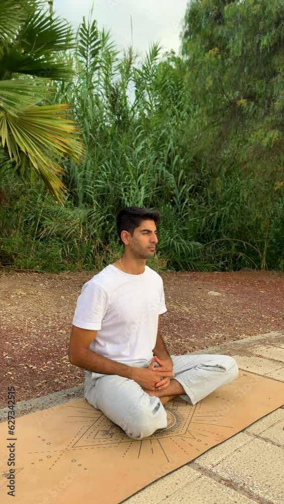 Hombre indio practicando técnicas de respiración. Sesión de meditación sobre colchoneta de yoga en el parque. Relax al aire libre para una mejor salud. Ejercicios de concentración por la mañana en ver
