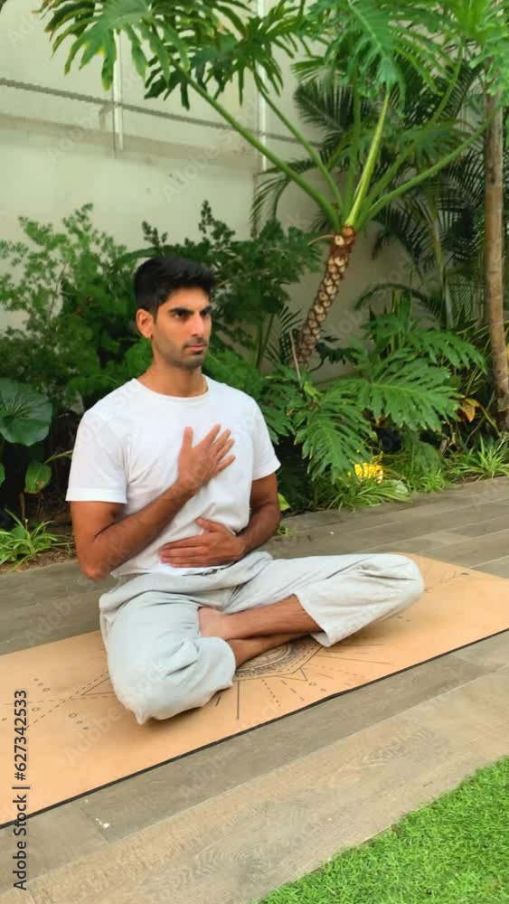 Hombre indio practicando técnicas de respiración. Sesión de meditación sobre colchoneta de yoga en el parque. Relax al aire libre para una mejor salud. Ejercicios de concentración por la mañana en ver